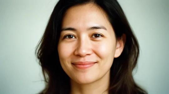 Un particulier consultant attentivement des documents de certification RGE avec un artisan en tenue professionnelle sur un chantier de rénovation