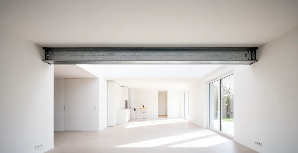 Vue d'une ouverture moderne dans un mur porteur avec poutre IPN métallique apparente soutenant la structure
