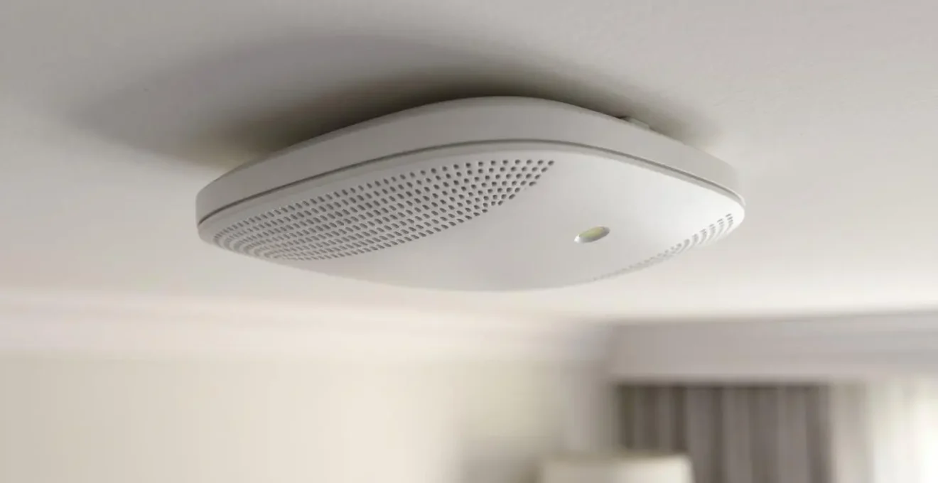 Capteur radar millimétrique installé discrètement au plafond d'une chambre de senior