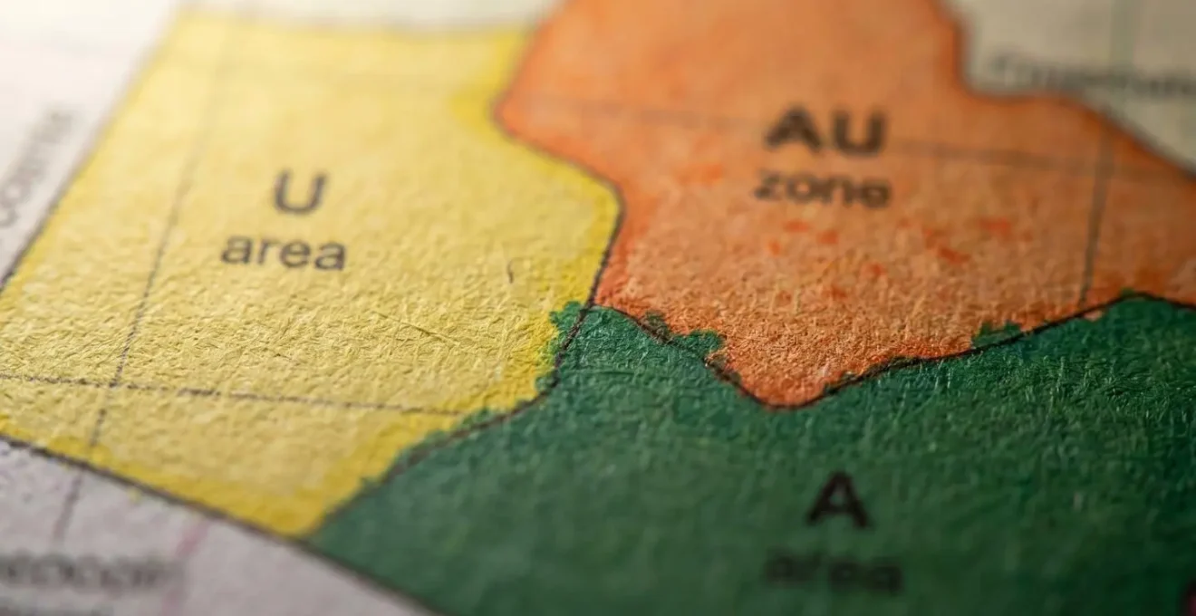 Gros plan sur une carte de zonage PLU avec zones colorées et légendes floues en arrière-plan
